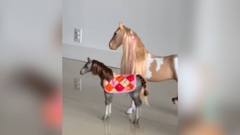 A pair of toy horses standing on the floor.