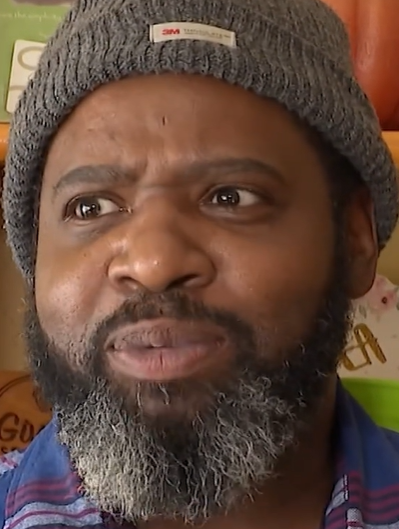 A man in a knit hat looking perplexed.