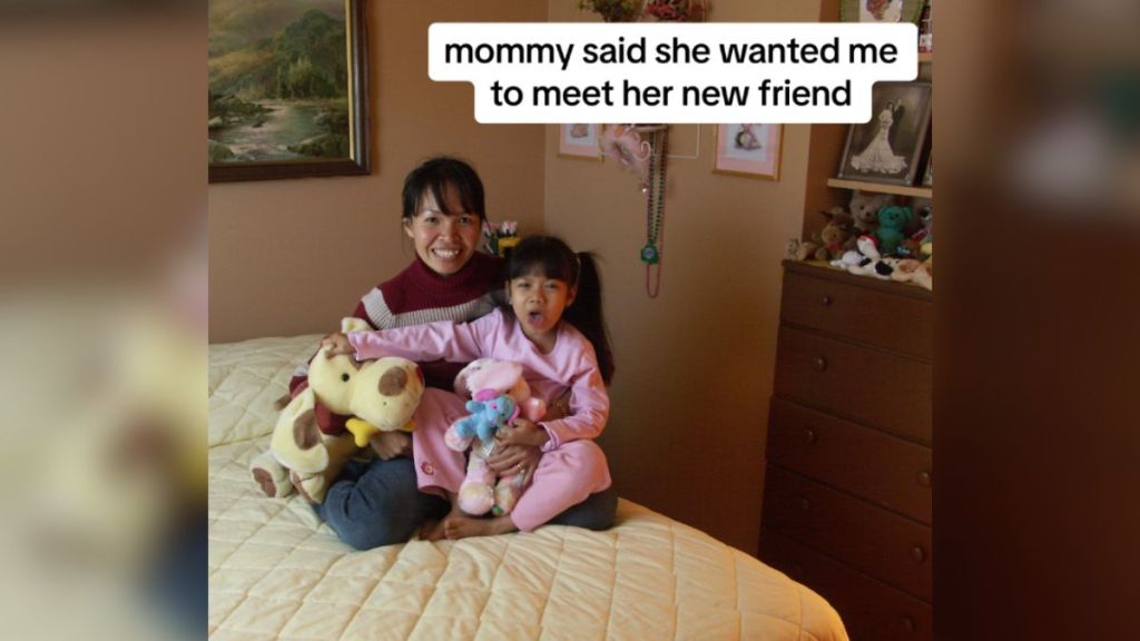 A woman and her young daughter sitting on the bed.