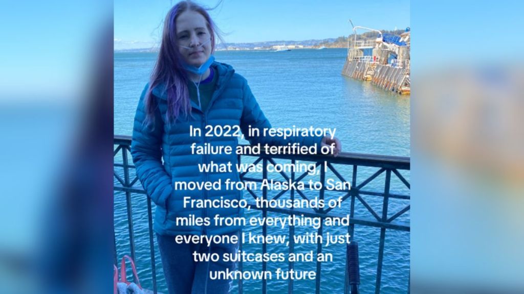 A young woman standing in front of a body of water.