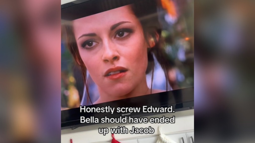 View of a TV playing a "Twilight" movie. There's a closeup of Bella on the screen that takes place during the wedding scene. Text on the image reads: Honestly screw Edward, Bella should have ended up with Jacob