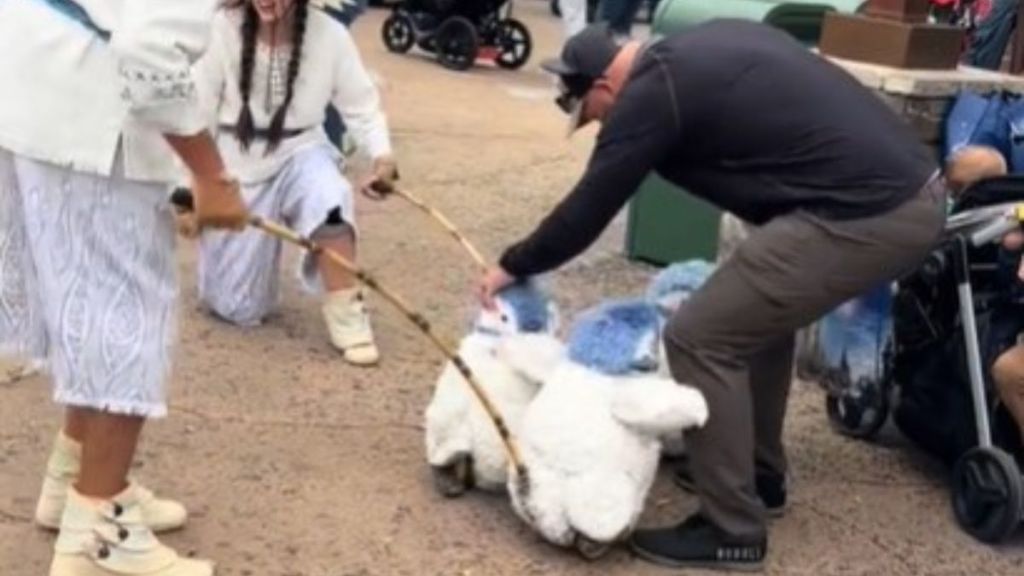 Image shows a man being "mauled" by baby Disney penguins.