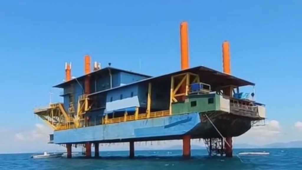 Image shows the side view of the oil rig turned into a dive resort.