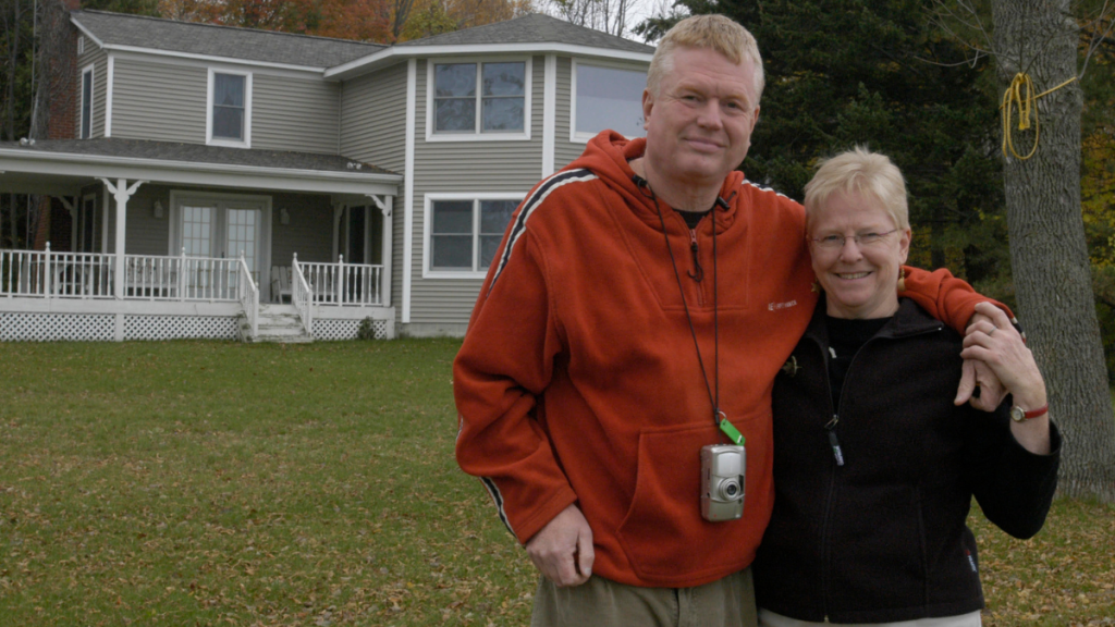 ed and kathleen pose together for a photo in front of a house