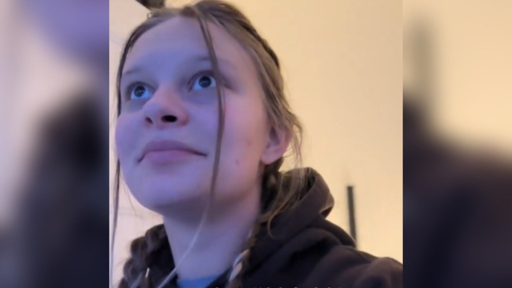 Close up of a woman who looks amazed, eyes wide, as she looks off in the distance at something that can't be seen in this image.