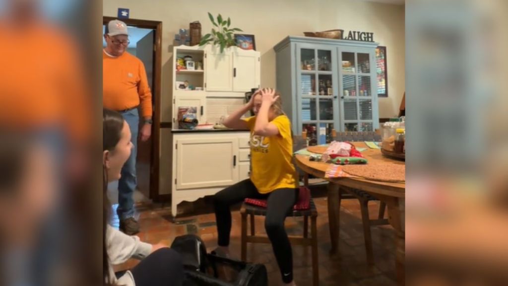 A young girl holding her head in her hands, overwhelmed with emotion.
