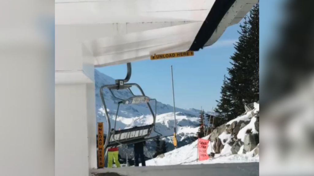 A chairlift at the top of a ski slope.