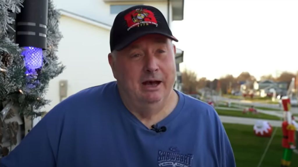A man standing outside in a residential neighborhood.