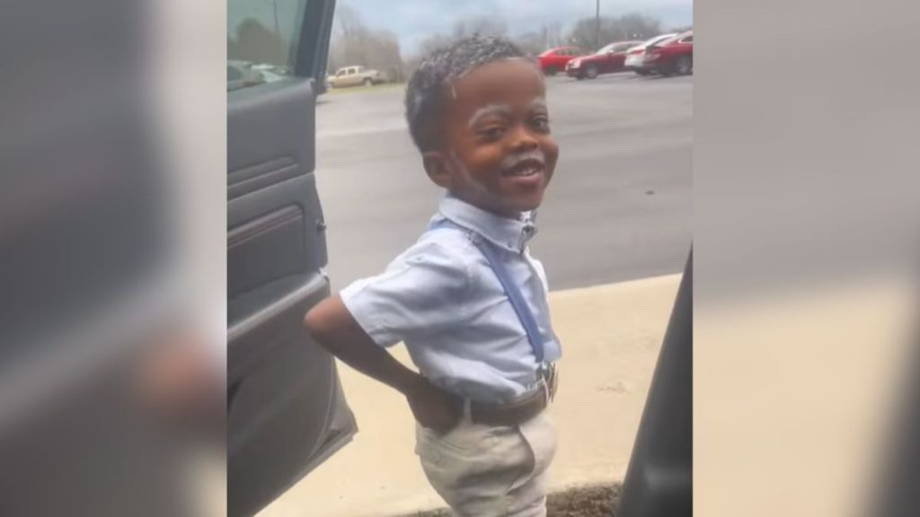 A little boy dressed up as an old man.