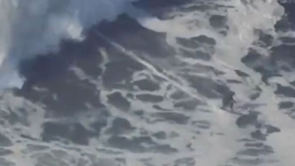 Image shows a surfer in the curl of a wave estimated at 115-feet. It was measured at 86 feet to breat the Guinness World Record in Oct 2020.