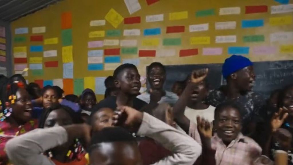 Image shows school children celebrating after receiving help from MrBeast's philanthropic organization.