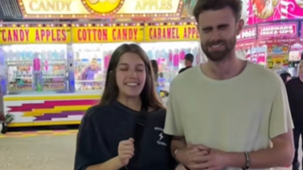Close up of a woman and man standing arm in arm at a fair