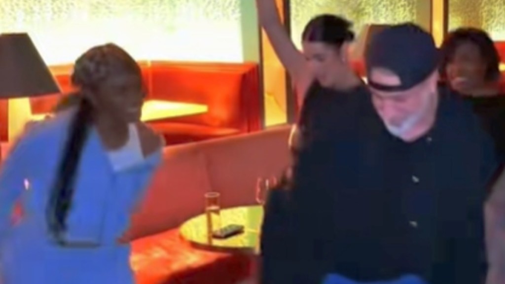 Joey Fatone dances with three NSYNC fans. Everyone is smiling.