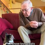 Image shows a Grandpa blowing kisses to a cat sitting on the floor in front of him.