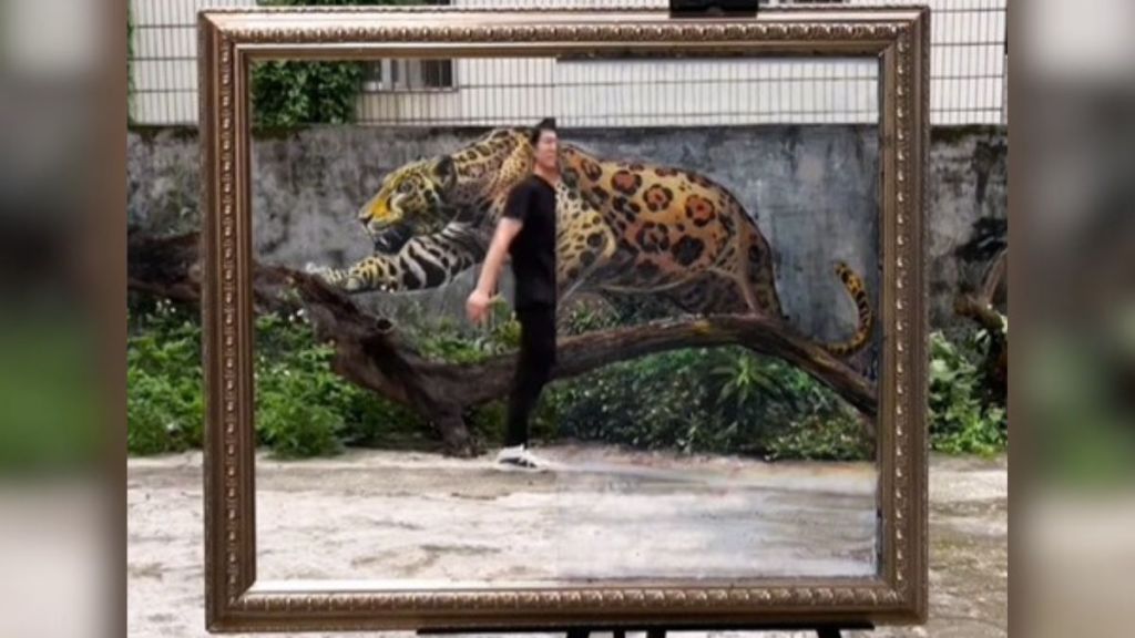Image shows artist Huang Yao walking into a lifelike painting of a leopard.