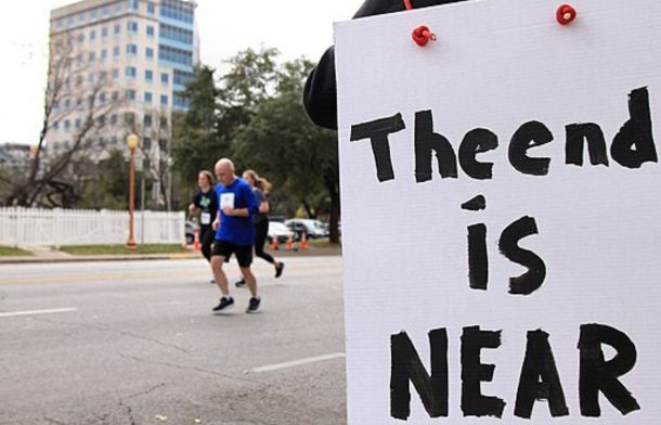 Image shows runners in the background with a sign saying "The End is Near."