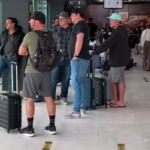 Image shows several dads looking out a window at an airport experiencing dad life.