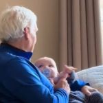 Image shows a Grandpa singing a lullaby to an infant.