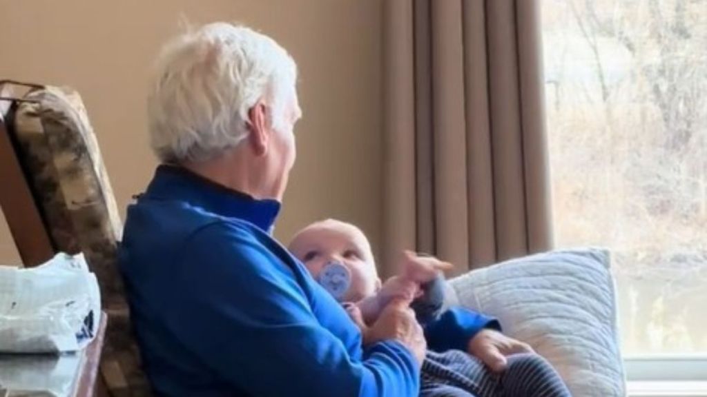 Image shows a Grandpa singing a lullaby to an infant.