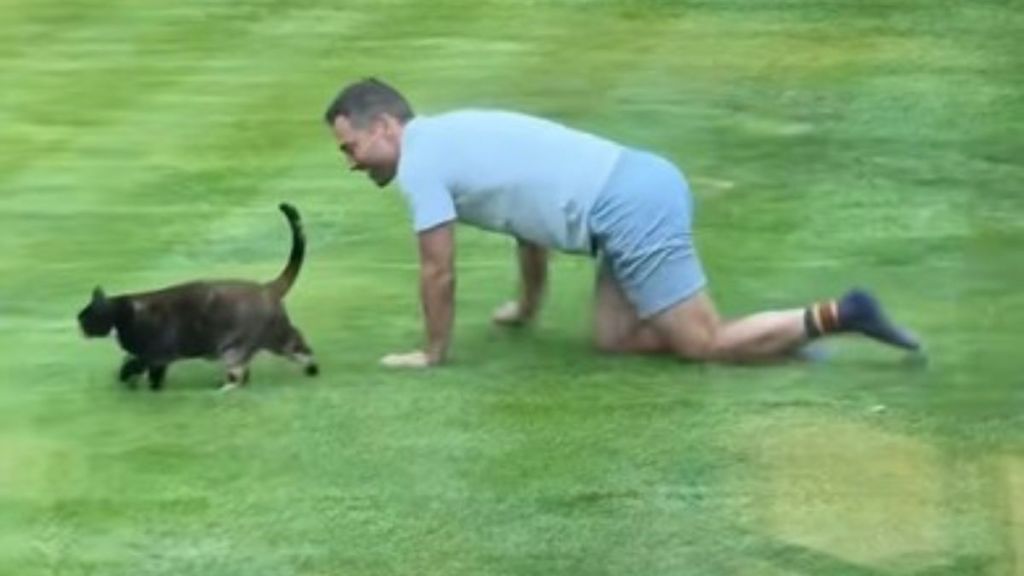 Image shows a husband out "hunting" with the cat he didn't want.
