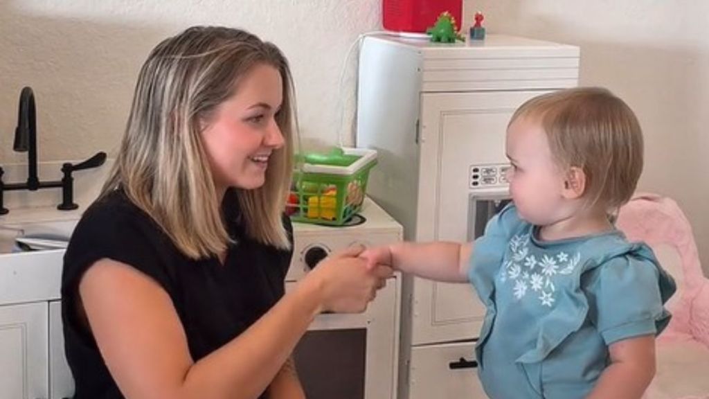 Teaching social skills is an important of parenting. Image shows a mom teaching her daughter how to shake hands.