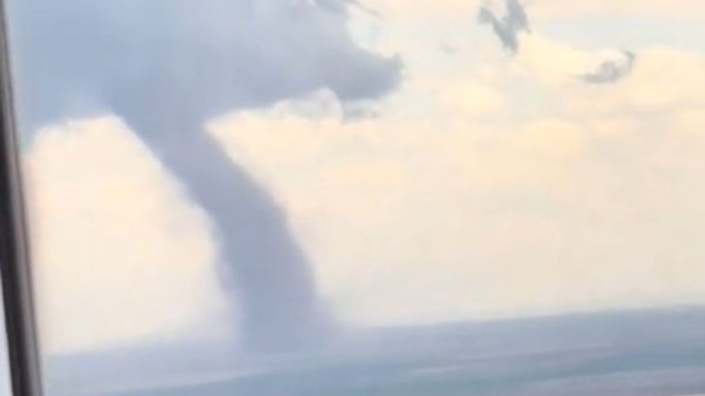 Image shows a frightening tornado over Denver as seen from an airplane window while in flight.