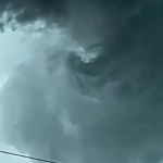 Image shows a potential tornado forming with rotational cloud movement.