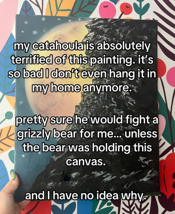 A hand holds up a large painting of a mountainside with a large moon peaking out from behind. Text on the image reads:
my catahoula is absolutely terrified of this painting. it's so bad I don't even hang it in my home anymore.
pretty sure he would fight a grizzly bear for me... unless the bear was holding this canvas
and I have no idea why