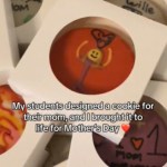 Cookies in small containers are stacked on top of each other, clearly designed by kids. Text on the image reads: "My students designed a cookie for their mom, and I brought it to life for Mother's Day"