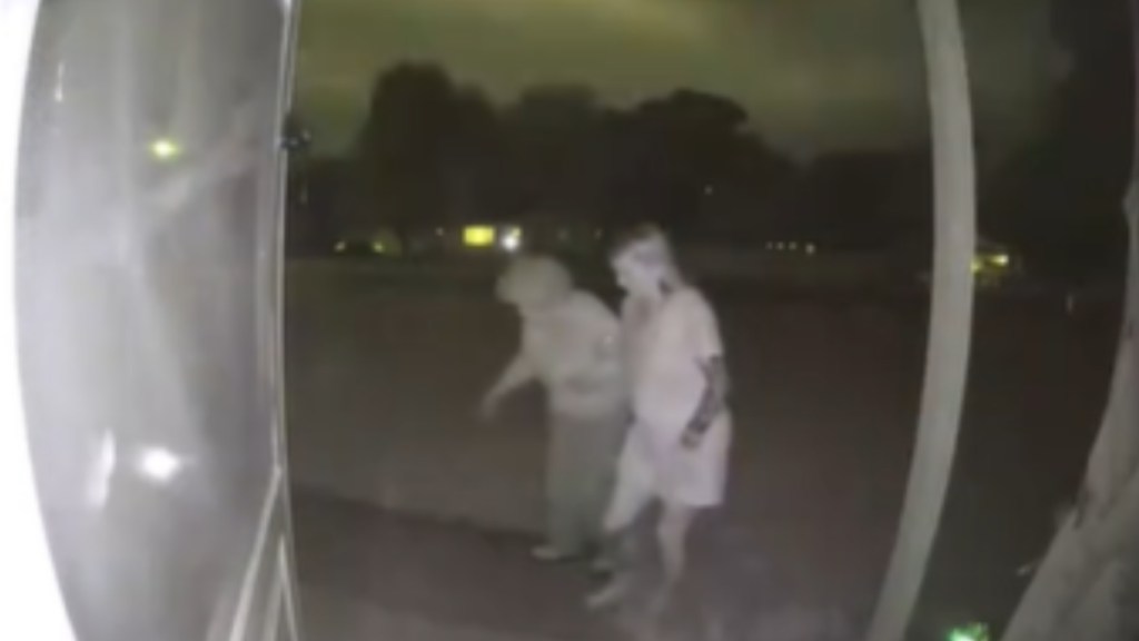 Front door camera shows a woman helping an elderly woman walk up to their home at night during a storm