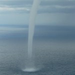A waterspout moves over the water