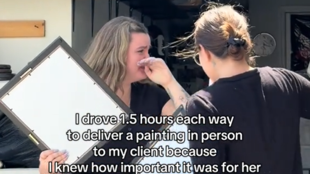 An artist delivering a painting in person to a client who is wiping away tears